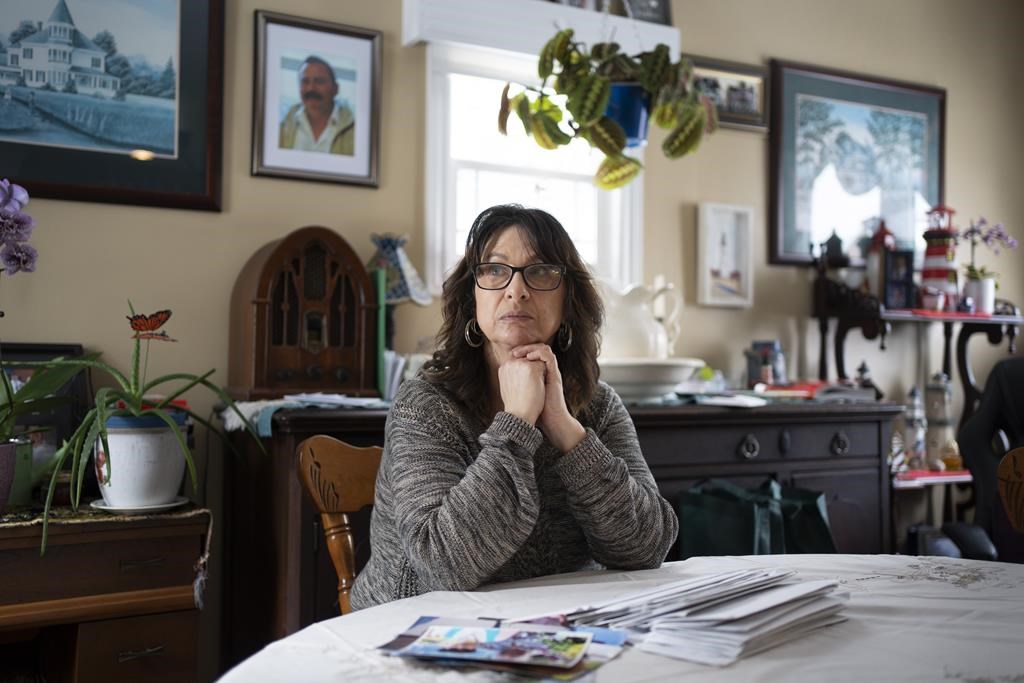 Mary Hendsbee sits at her table in Auld’s Cove, N.S. on Friday, February 16, 2024 with photos of her late husband Richard “Dougie” Murray and letters he sent before killing himself in the Burnside Correctional Facility on January 15, 2024.