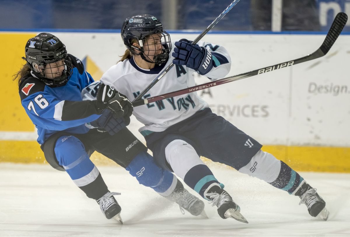 New York's Alex Carpenter (25) tumbles while battling with Toronto's Maude Poulin-Labelle (76) during first period PWHL action in Toronto on Friday, January 26, 2024.