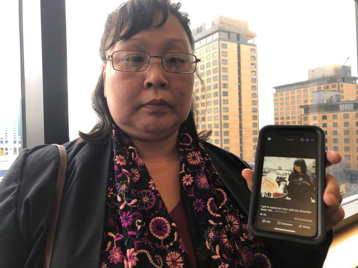 Rena Sapp, outside a courtroom Monday, Oct. 21, 2019, in Anchorage, Alaska, shows a photo of her sister, Veronica Abouchuk, taken during a day out shopping in 2013.