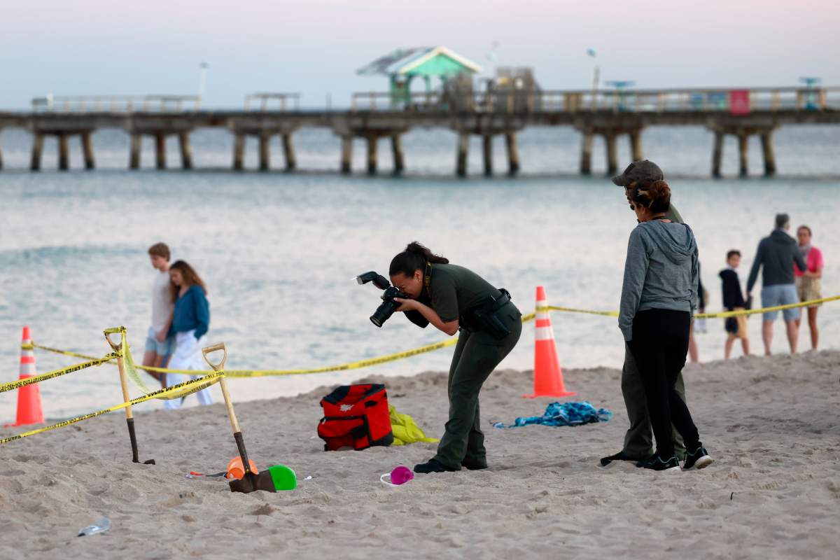 Investigators on the beach in Lauderdale-by-the-Sea, Fla., take photos of the scene of a sand collapse on Tuesday, Feb. 20, 2024.
