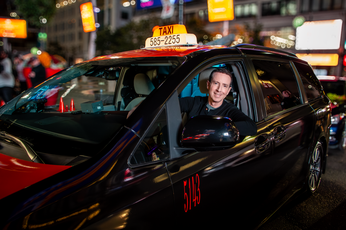 Host Adam Growe behind the wheel of the new 'Cash Cab' taxi.