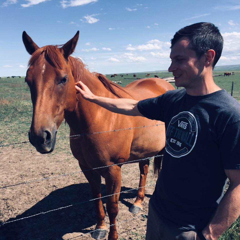 An undated photo of Edmonton homicide victim Cody Lyle, 35, petting a horse.