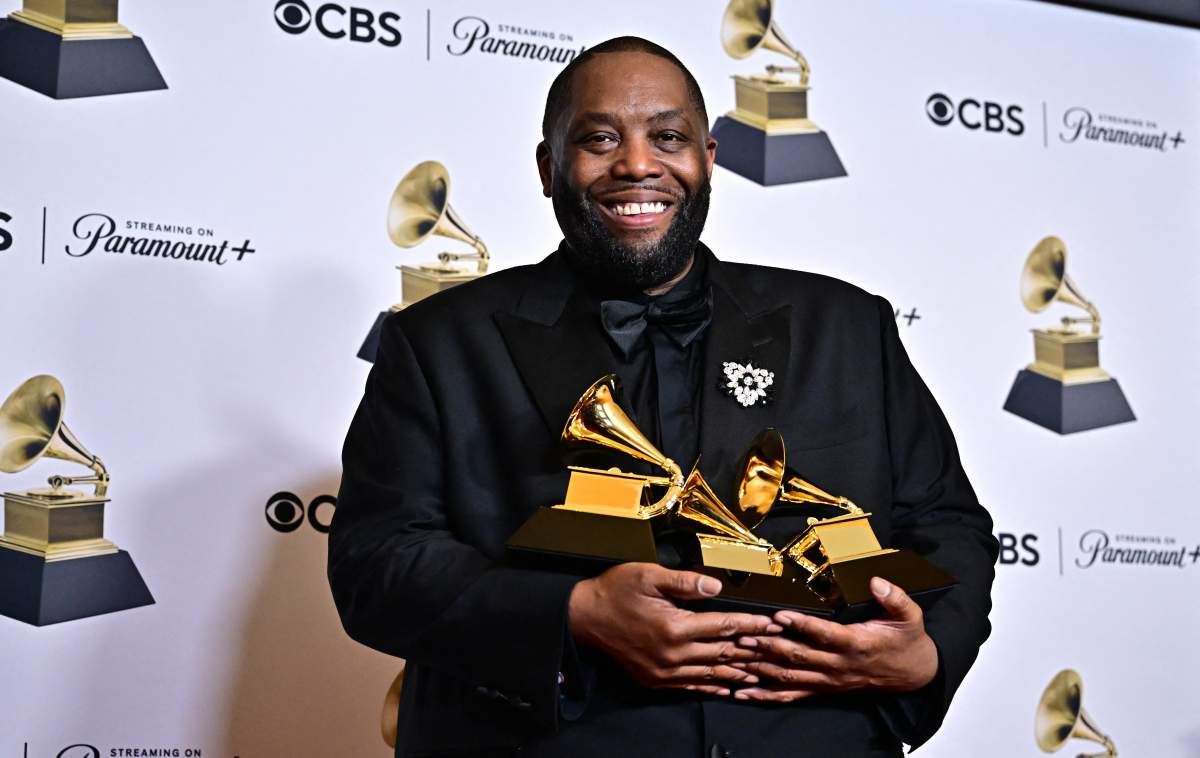 Killer Mike holding three Grammy Awards.