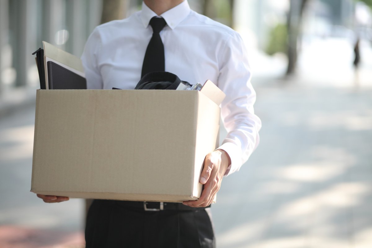 Businessperson Carrying Cardboard Box because he has been laid off
