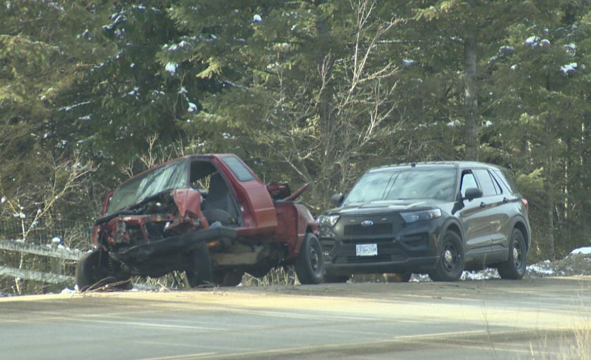 An unmarked police cruiser is parked behind one of the vehicles involved in Saturday's collision along Highway 33, east of Kelowna, B.C.