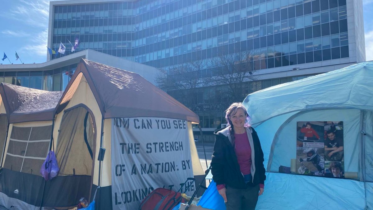 Poverty advocate Angela Vos alongside an encampment that popped up Feb. 26, 2024 in front of Hamilton city hall’s forecourt. The demonstration is in response to a council vote that opted to leave a pair of parking lots in Stoney Creek out of plan to build affordable housing.