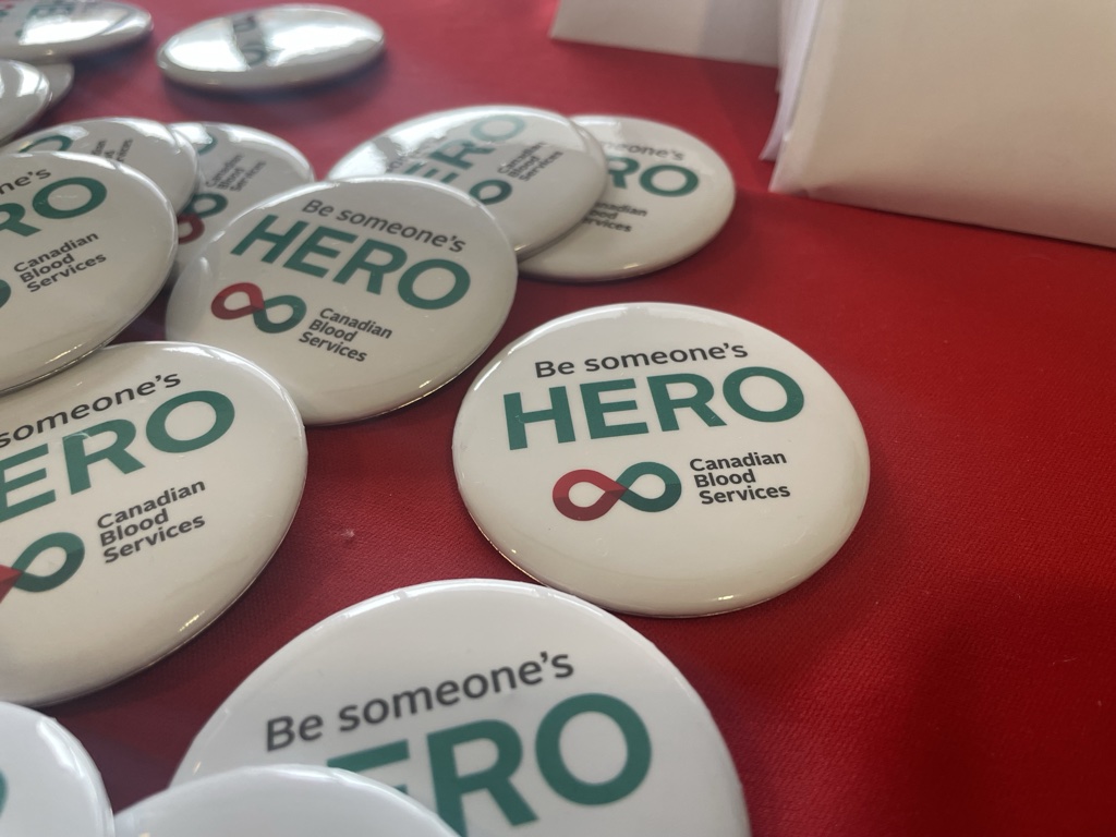 “Be someone’s hero” is written on pins laid across a Canadian Blood Services registration desk at Dalhousie University on Friday.