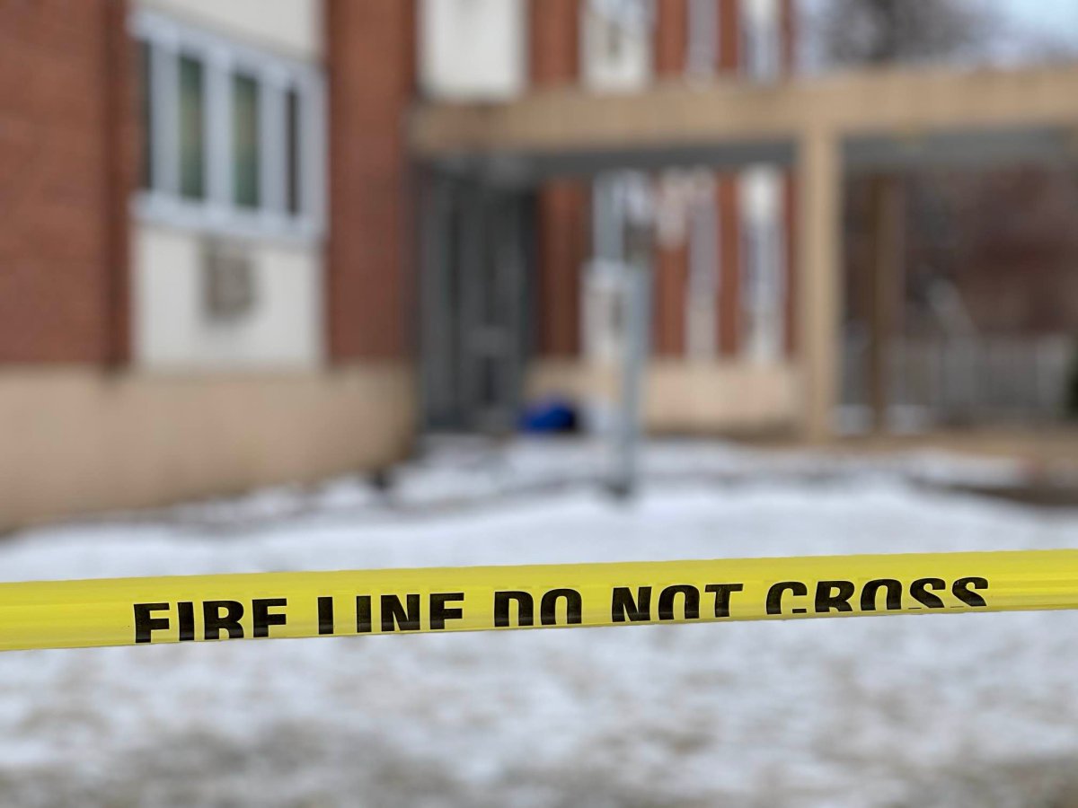 Winnipeg fire tape with apartment building in the background.