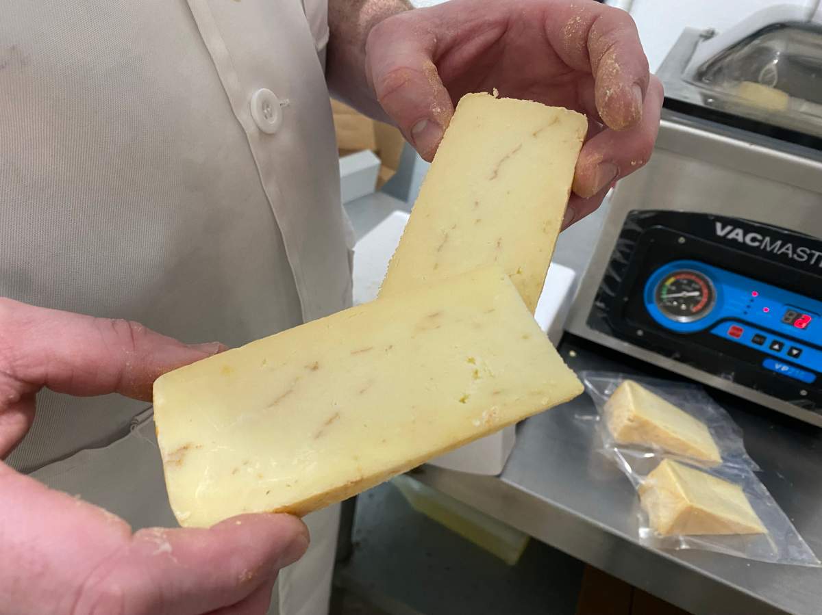 Dustin Peltier, owner of Loaf and Honey holding his special cheese.