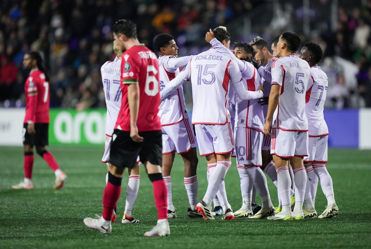 Orlando City's Facundo Torres (10) and Rodrigo Schlegel (15) celebrate Torres' goal as Cavalry FC's Charlie Trafford, front left, walks past during the first half of a CONCACAF Champions Cup soccer match, in Langford, B.C., on Wednesday, February 21, 2024.