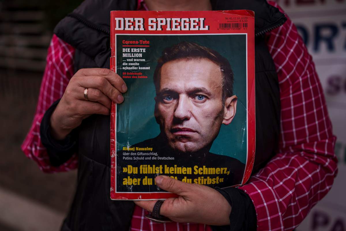A woman holds a magazine with a portrait of Russian opposition leader Alexei Navalny in front of the Russian Embassy in Madrid, Spain, Friday, Feb. 16, 2024. Alexei Navalny, who crusaded against official corruption and staged massive anti-Kremlin protests as President Vladimir Putin’s fiercest foe, has died in the Arctic penal colony where he was serving a 19-year sentence. That’s according to Russia’s prison agency. He was 47. (AP Photo/Manu Fernandez)