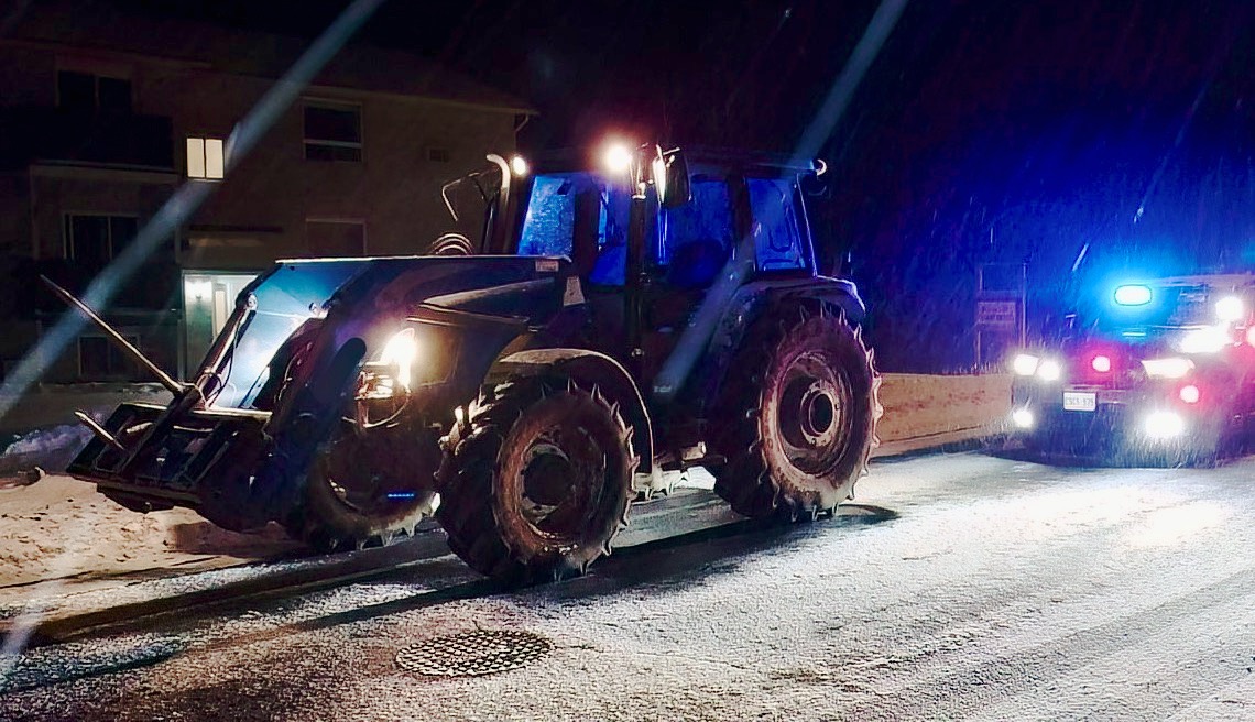 A farm tractor is stopped as an OPP cruiser has its lights flashing. The driver of the tractor was arrested for impaired driving.