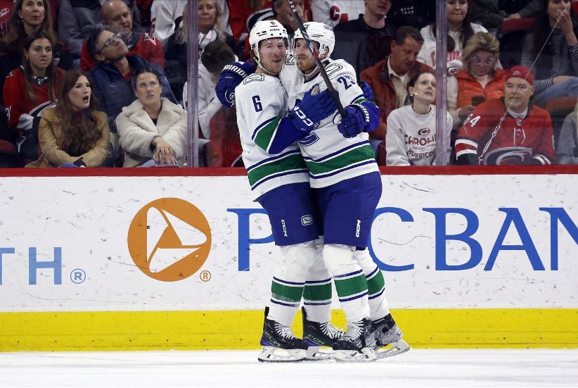 Vancouver Canucks Elias Lindholm, right, celebrates his second goal against the Carolina Hurricanes with Brock Boeser (6), during the game in Raleigh, N.C., on Feb. 6.