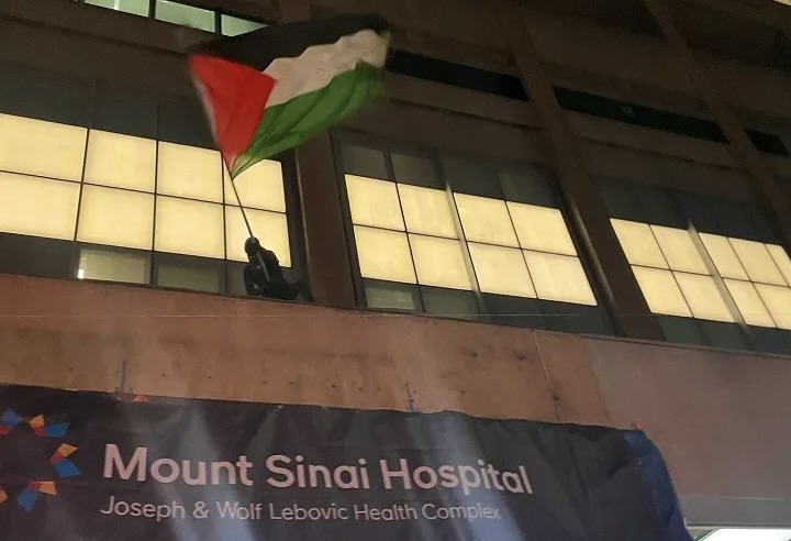 Protestors climb Mount Sinai Hospital to wave Palestinian flag, Feb. 12, 2024.