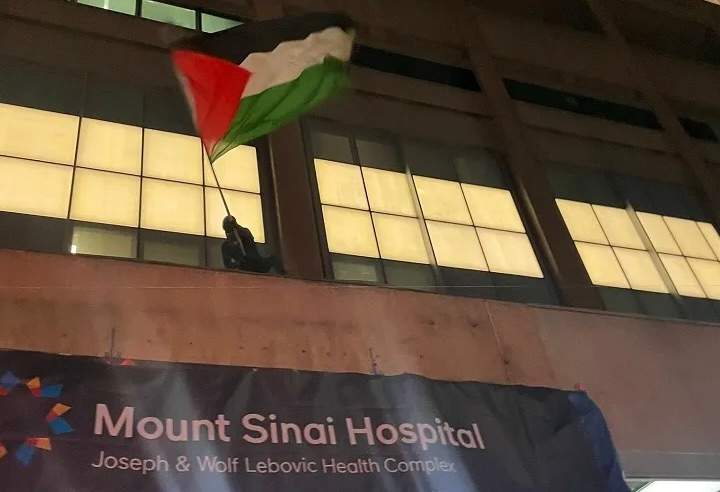 Protestors climb Mount Sinai Hospital to wave Palestinian flag, Feb. 12, 2024.