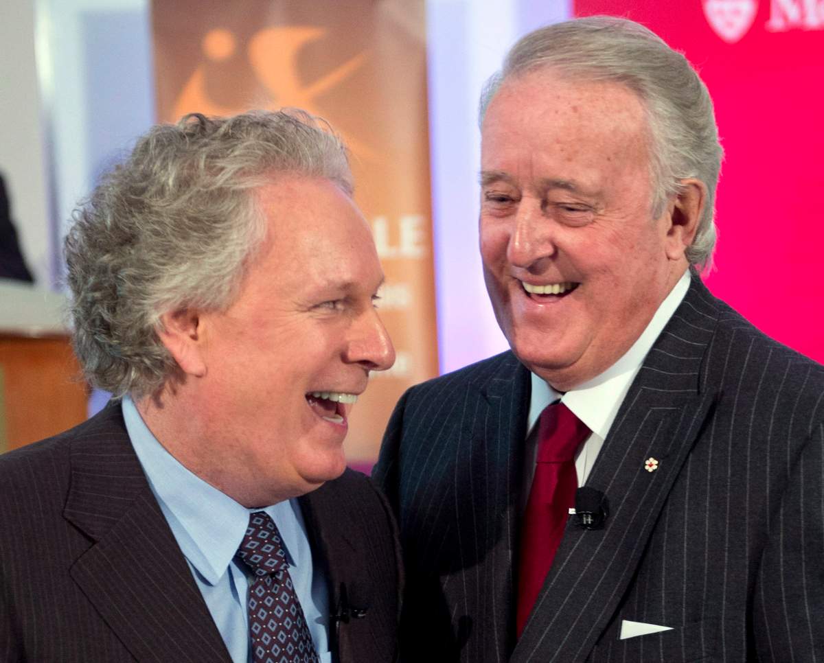 Former Prime Minister Brian Mulroney, right, arrives with former Quebec Premier Jean Charest at a tribute for Claude Ryan Friday, February 14, 2014 in Montreal