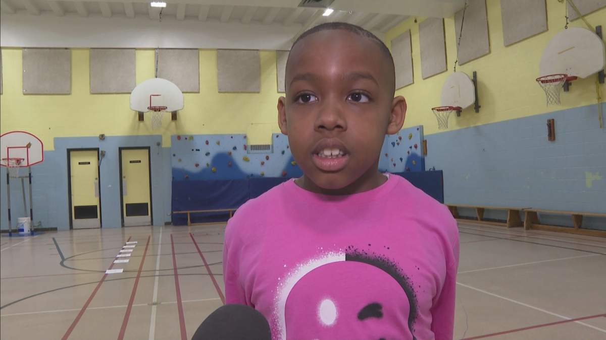 A boy is seen wearing a pink shirt on Pink Shirt Day.
