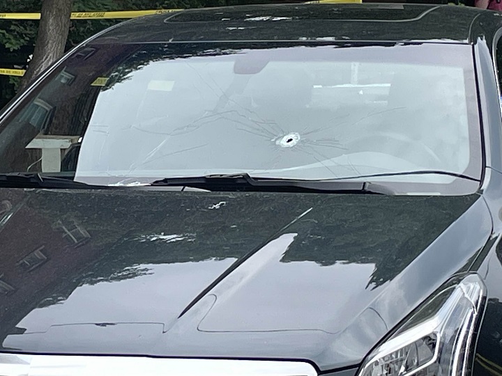 A bullet hole is seen in the windshield of the Cadillac on June 11, 2023.