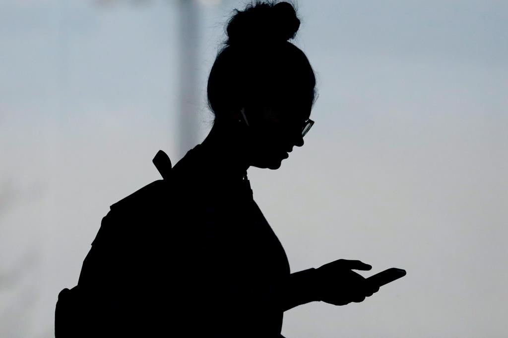 A woman checks her phone in Orem, Utah on Nov. 14, 2019. THE CANADIAN PRESS/AP, Rick Bowmer.