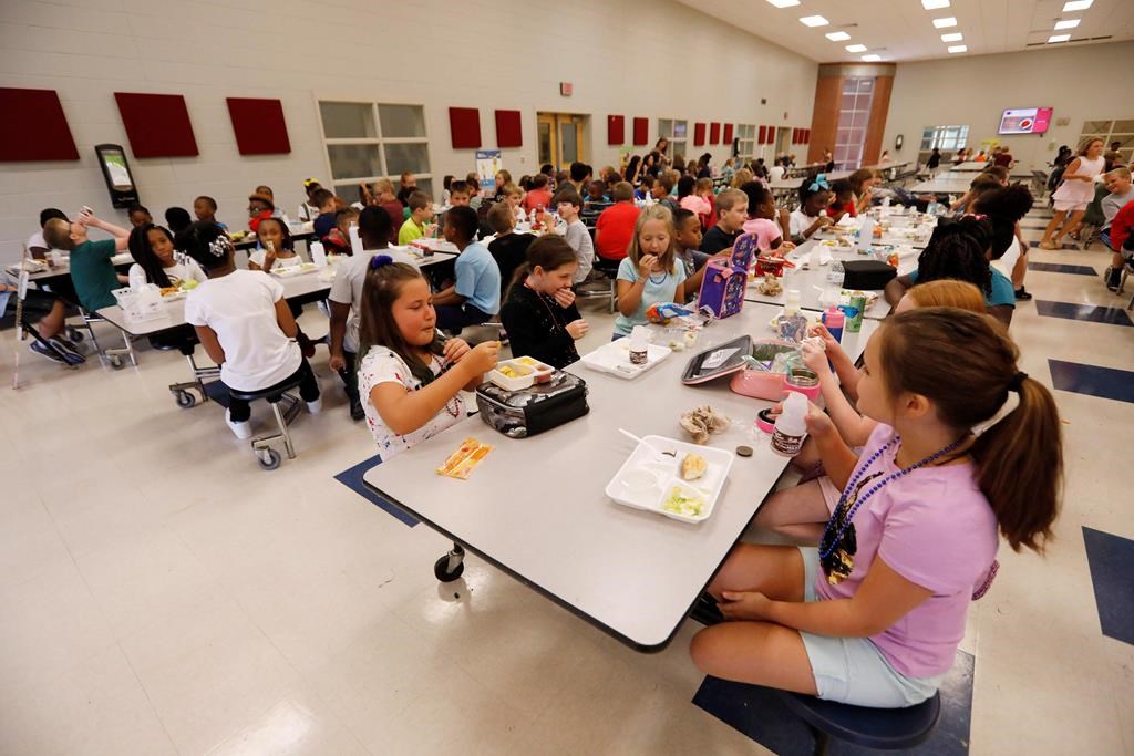 Half of a tangerine instead of a whole one, half of a hard-boiled egg or an apple cut six ways — student nutrition programs across Ontario are finding ways to stretch increasingly insufficient dollars. Students at Madison Crossing Elementary School in Canton, Miss., eat lunch in the school's cafeteria on Friday, Aug. 9, 2019. THE CANADIAN PRESS/AP-Rogelio V. Solis.