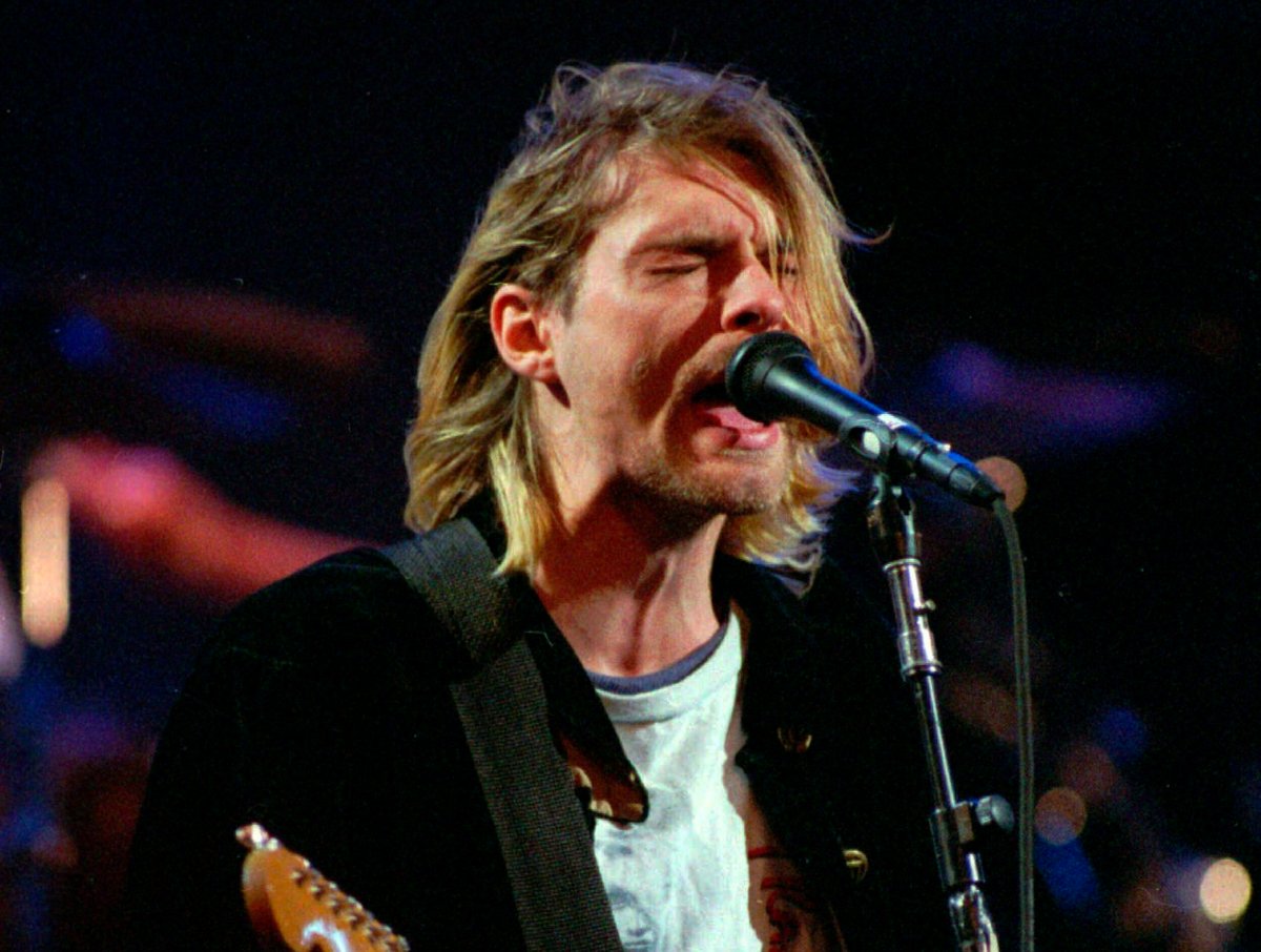 Nirvana frontman Kurt Cobain sings into a microphone.