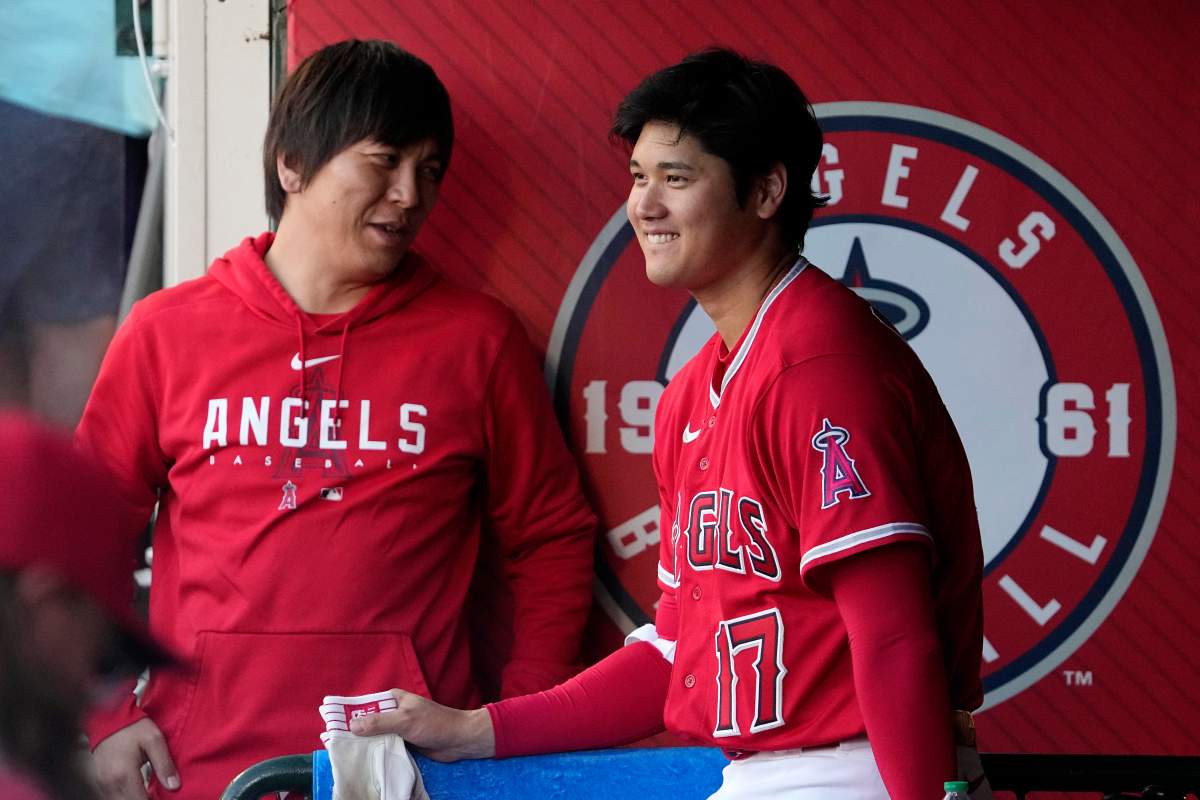 Los Angeles Angels' Shohei Ohtani, right, laughs as he talks to his interpreter Ippei Mizuhara in the dugout during the first inning of a baseball game against the New York Yankees Tuesday, July 18, 2023, in Anaheim, Calif.