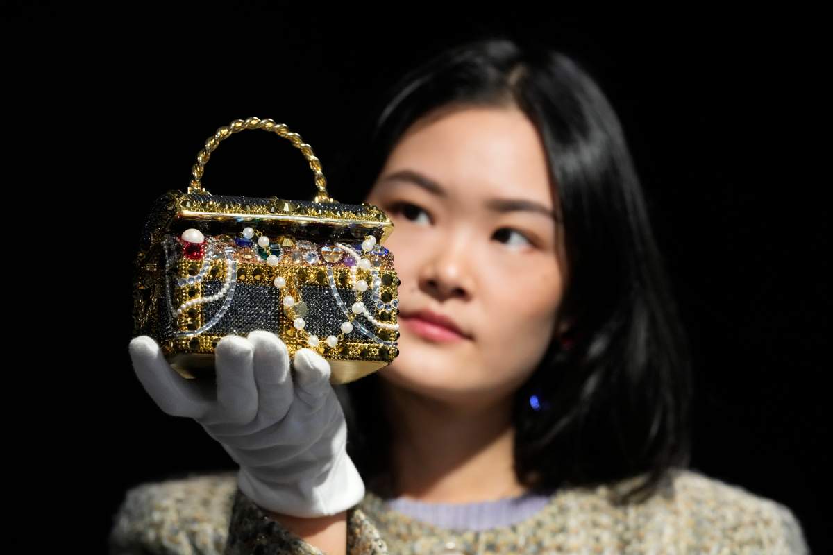 A Bonhams employee displays a Judith Leiber: a Gold ‘Sunken Treasure Chest’ Clutch Bag at the auction rooms in London, Monday, Feb. 26, 2024. The bag estimated at 600-800 UK Pounds (760-1015 US Dollars) will be for auction in the live sale on Feb. 28, it will feature luxurious items of handbags and ready-to-wear designs from coveted names including Chanel, Hermes, Karl Lagerfeld for Chanel, Christian Dior, Louis Vuitton, and Gucci.
