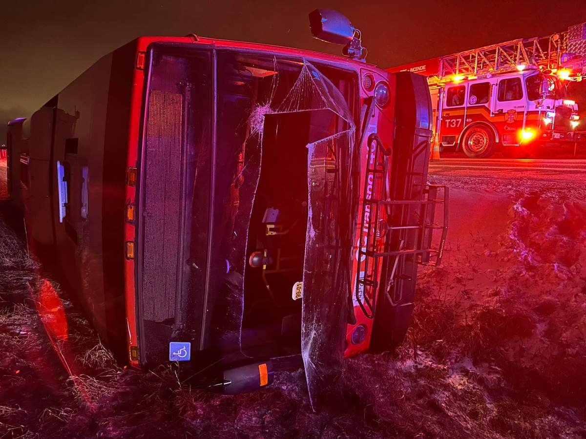 An Ottawa Fire Services apparatus is seen on the road beside an OC Transpo bus tipped over into a ditch, in Ottawa, in a Sunday, March 10, 2024, handout photo published to X, formerly known as Twitter. 