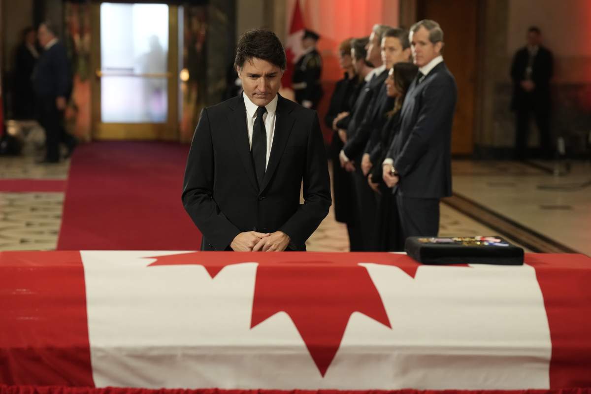 Prime Minister Justin Trudeau stands next to the flag-draped casket of Brian Mulroney.