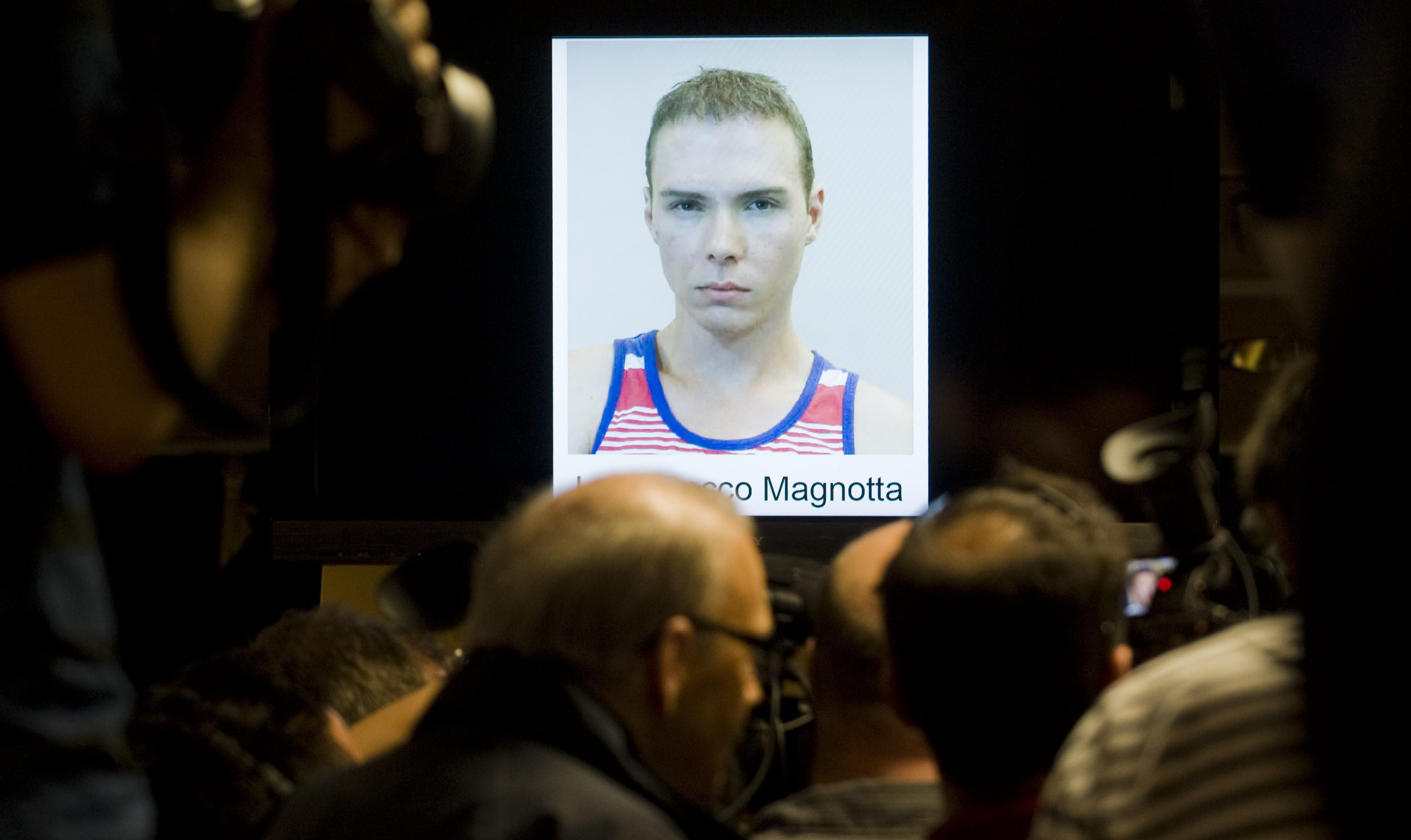 A poster of Luka Magnotta is shown at a news conference.