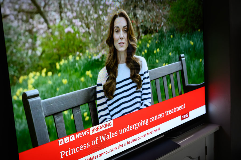 A screen displays a news report, as Catherine, The Princess of Wales announces that she is receiving a preventative course of chemotherapy for cancer on March 22, 2024 in London, England.
