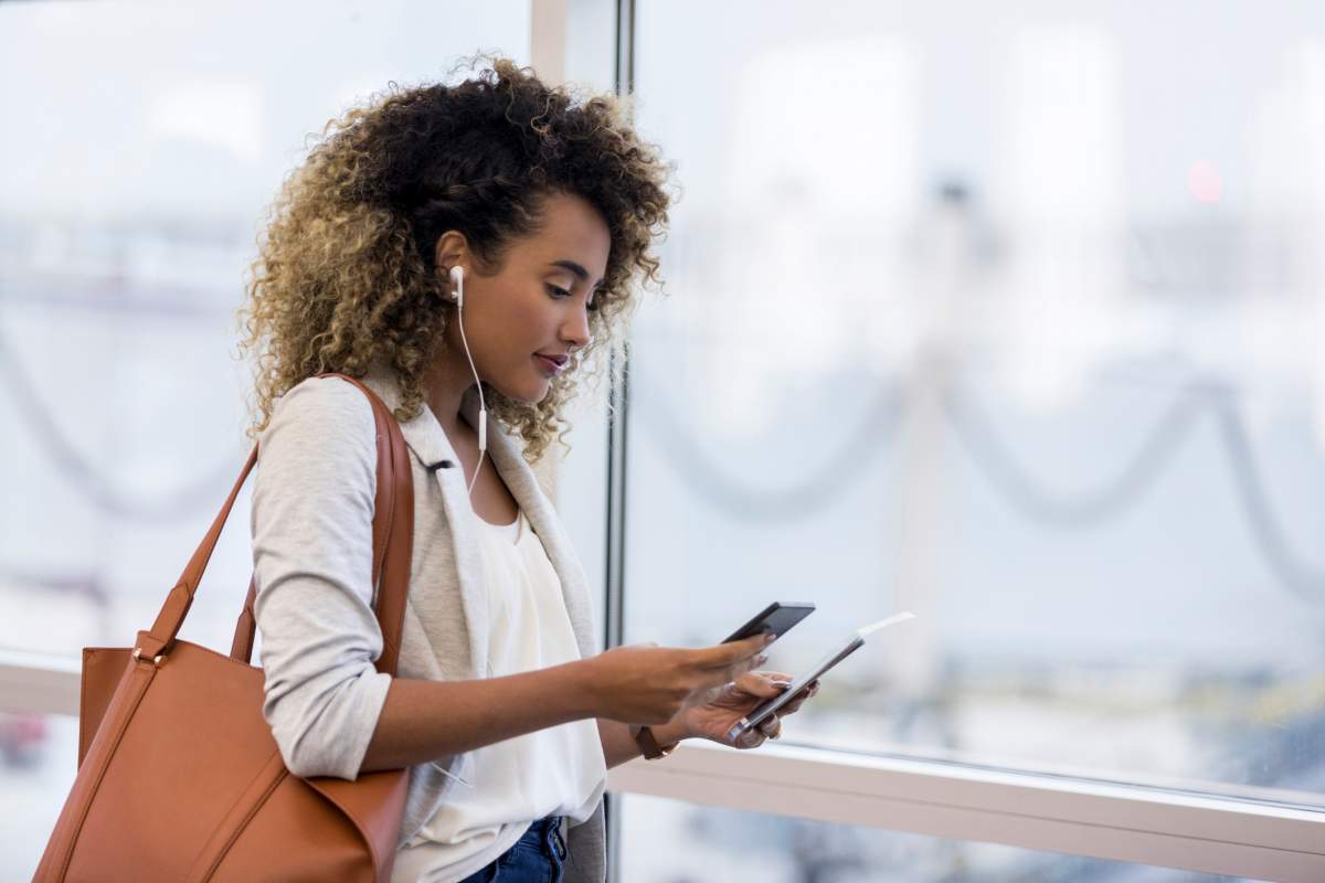 Woman at an airport with a personal bag over her shoulder