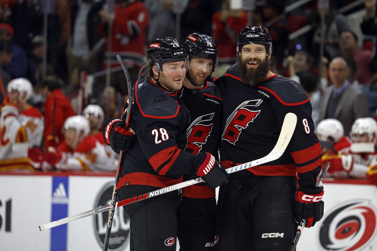 Carolina Hurricanes' Brent Burns (8) celebrates his goal with Carolina Hurricanes' Jaccob Slavin, center, and Brendan Lemieux (28) during the second period of an NHL hockey game against the Calgary Flames in Raleigh, N.C., Sunday, March 10, 2024.