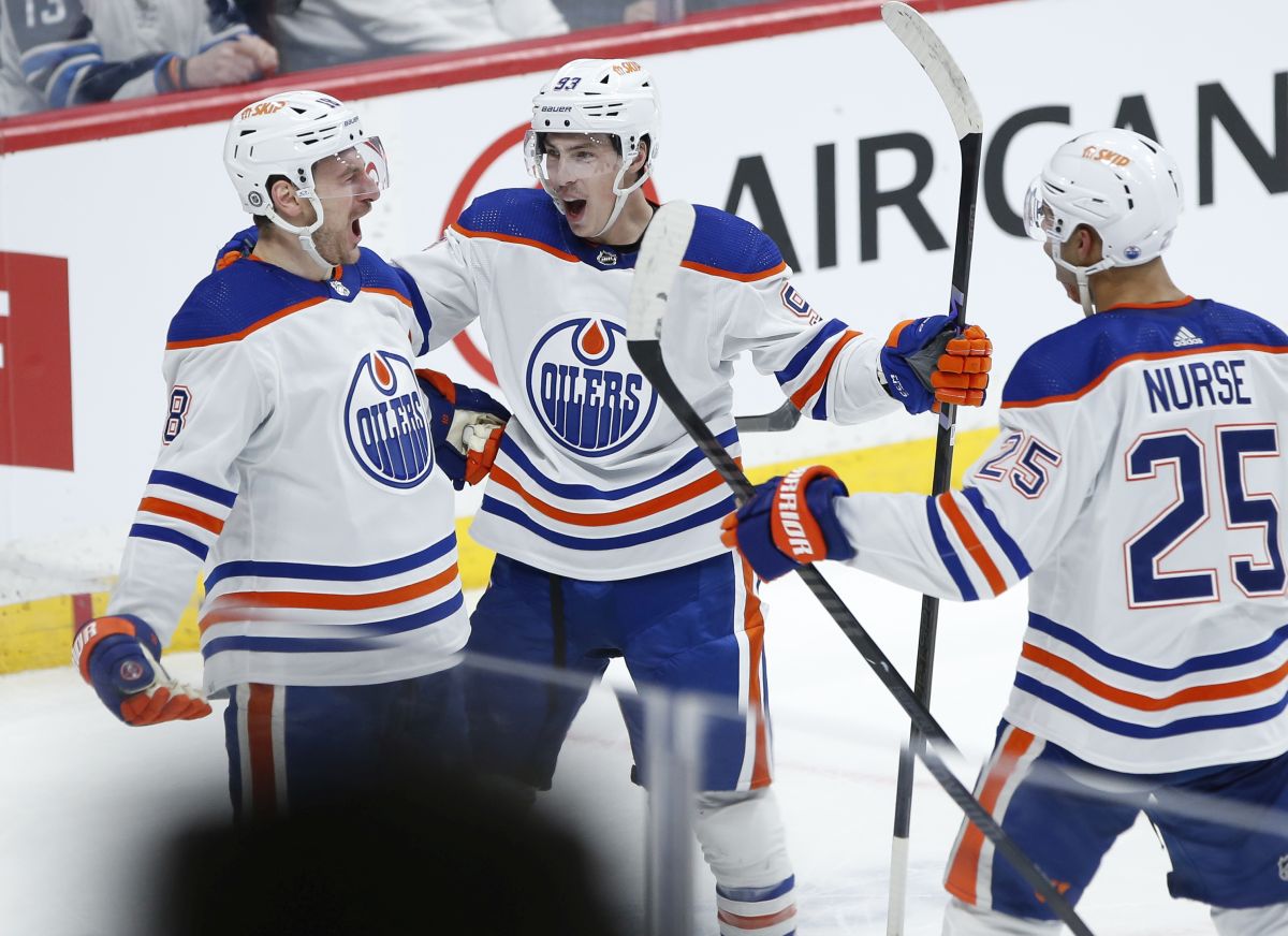 Edmonton Oilers' Zach Hyman (18), Ryan Nugent-Hopkins (93) and Darnell Nurse (25) celebrate Hyman's game-winning goal against the Winnipeg Jets in NHL overtime action in Winnipeg on Tuesday, March 26, 2024.