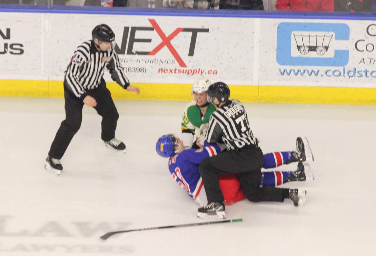 Max McCue of the London Knights and Mitch Martin of the Kitchener Rangers fall to the ice after an early fight.