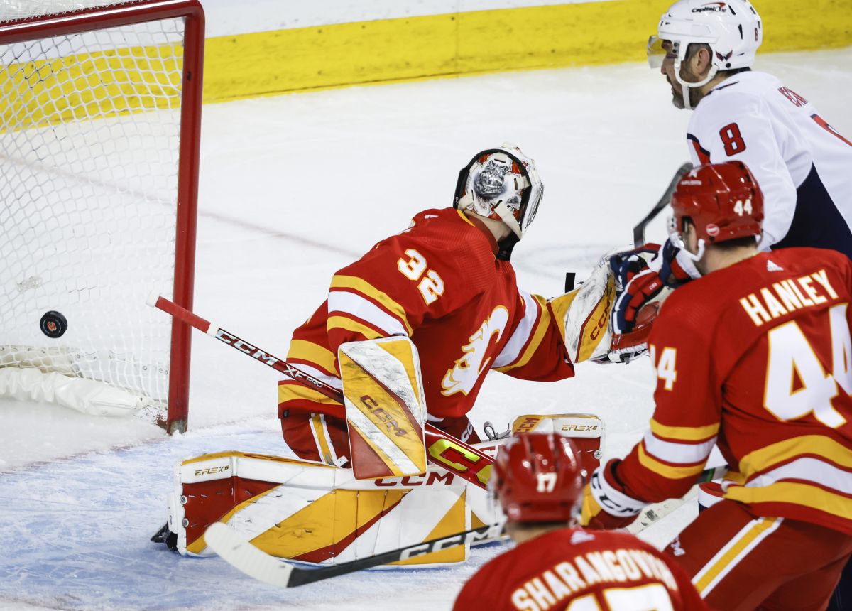 Washington Capitals forward Alex Ovechkin (8) scores on Calgary Flames goalie Dustin Wolf (32) during second period NHL hockey action in Calgary, Alta., Monday, March 18, 2024.