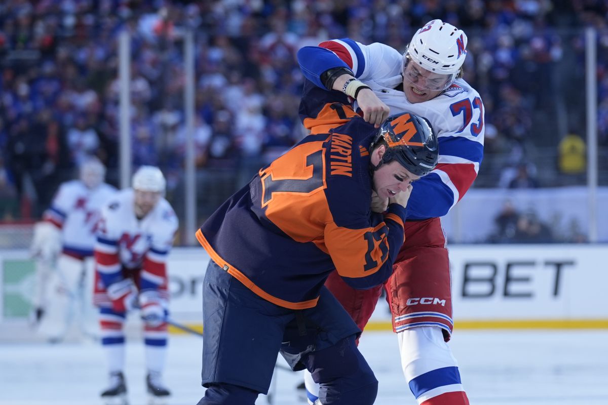 New York Rangers' Matt Rempe, top, fights with New York Islanders' Matt Martin during the first period of an NHL Stadium Series hockey game in East Rutherford, N.J., Sunday, Feb. 18, 2024.