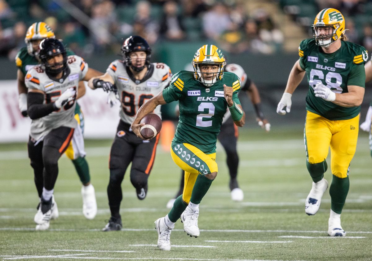 Edmonton Elks quarterback Tre Ford (2) runs the ball as B.C. Lions' Mathieu Betts (90) and Woody Baron (58) chase during first half CFL action in Edmonton on Friday, September 22, 2023.