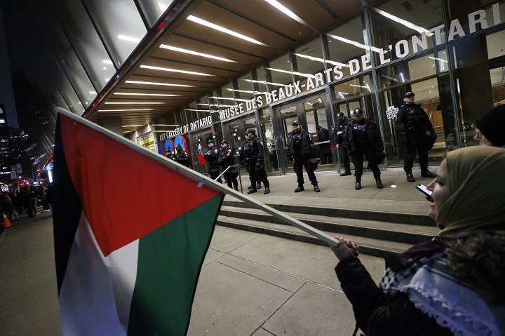 Protestors wave flags and sing as police line the entrance to the Art Gallery of Ontario, where a cancelled event for Canada's Prime Minister Justin Trudeau and Italy's Prime Minister Giorgia Meloni, was to take place, in Toronto, Saturday, Mar. 2, 2024.   