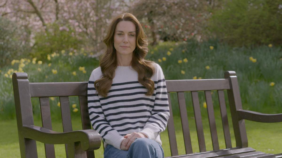 Kate Middleton, the Princess of Wales, sits on a bench in a garden