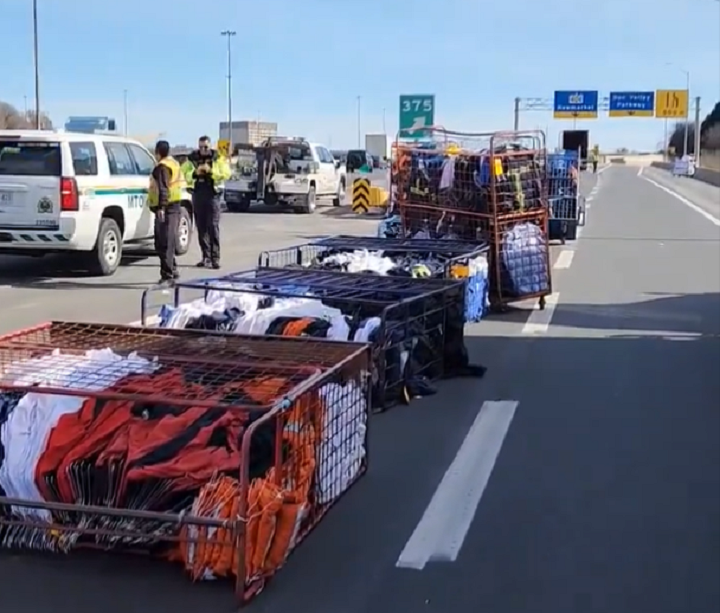 Racks and crates of clothing, linens across Highway 401 in Toronto after a truck lost its load on March 8, 2024.
