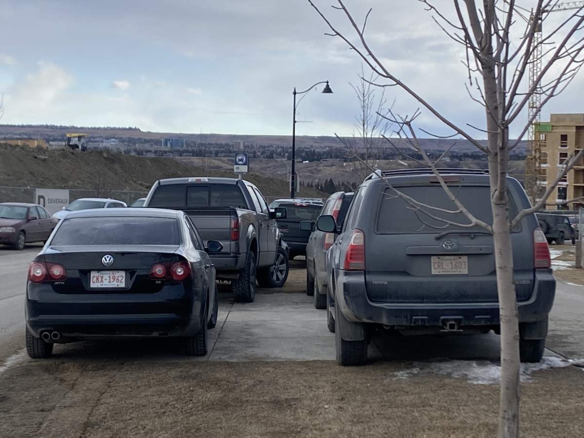 Vehicles parked on a Calgary Transit bus stop pad along Na’a Dr S.W.