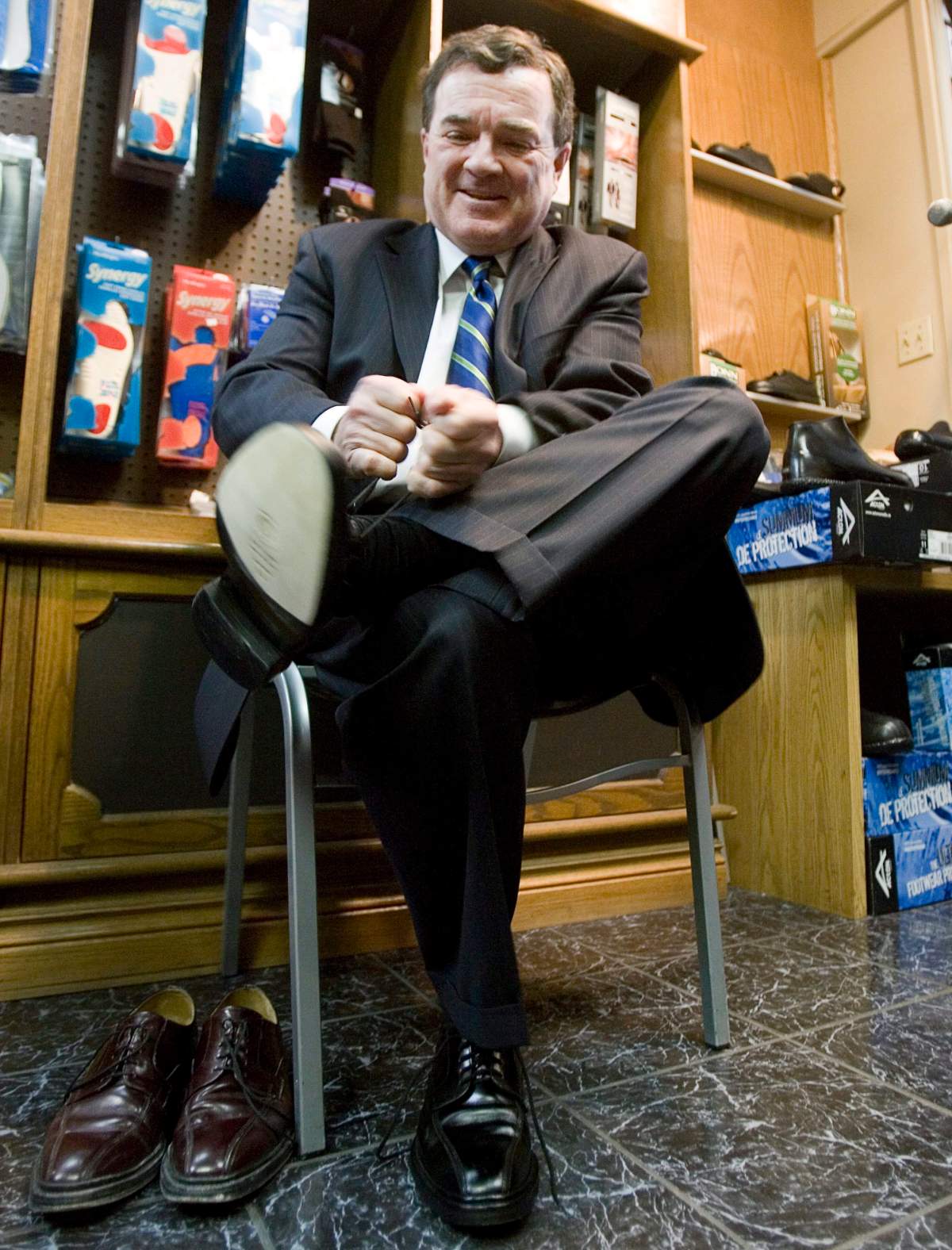 Finance Minister Jim Flaherty laces up his newly-resoled shoes during a traditional pre-budget photo op at a local shoe repair store in Ottawa Monday, Feb. 25, 2008.