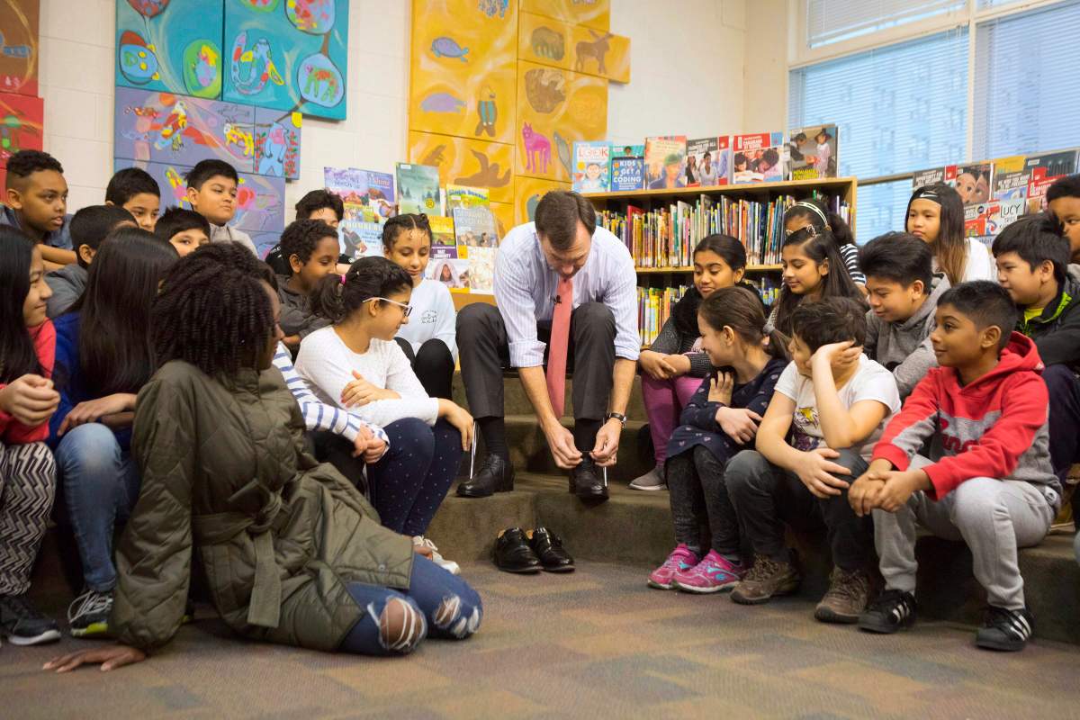 Federal Finance Minister Bill Morneau is joined by students from Toronto's Rose Avenue Junior Public School and his adopted daughter Grace as he tries on a pair of shoes from Edmonton's Poppy Barley Shoe manufacturer during a pre-budget photo opportunity in Toronto on Friday February 23, 2018.