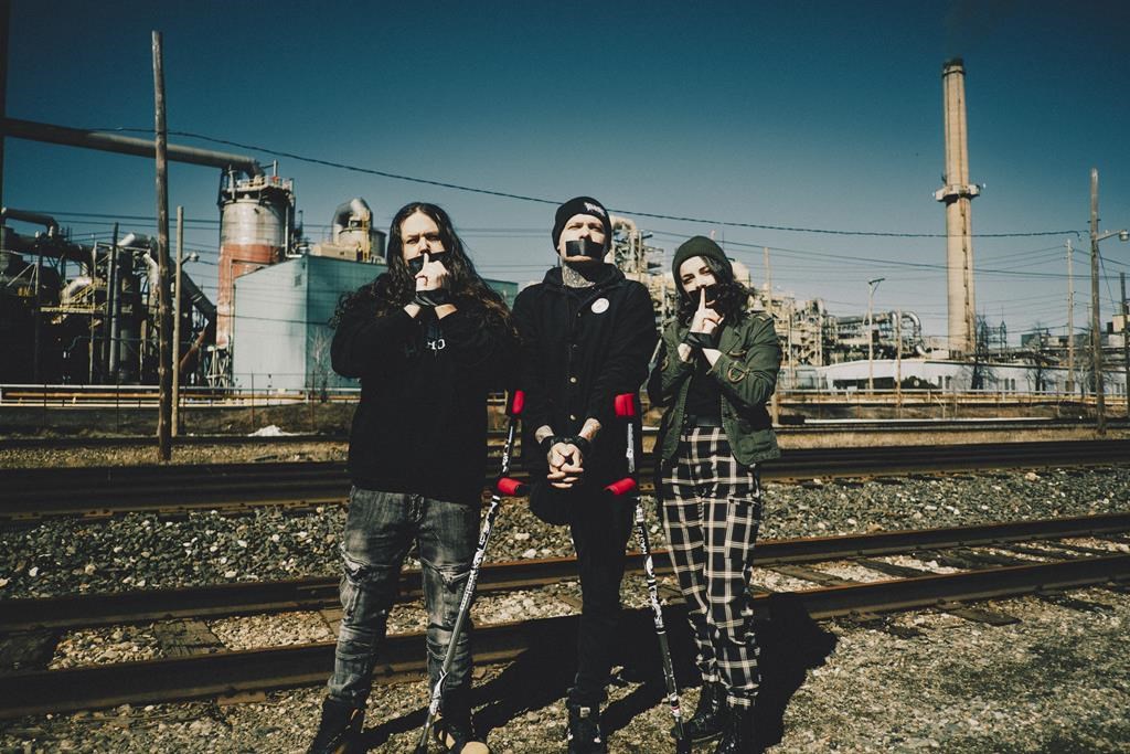 Members of the metal band Guhn Twei stand in front of the Horne copper smelter in Rouyn-Noranda, Que., in an undated handout photo. A music festival in western Quebec has been cancelled after a local band accused organizers of rescinding an invitation to perform because of its criticism of an arsenic-emitting copper smelter. 