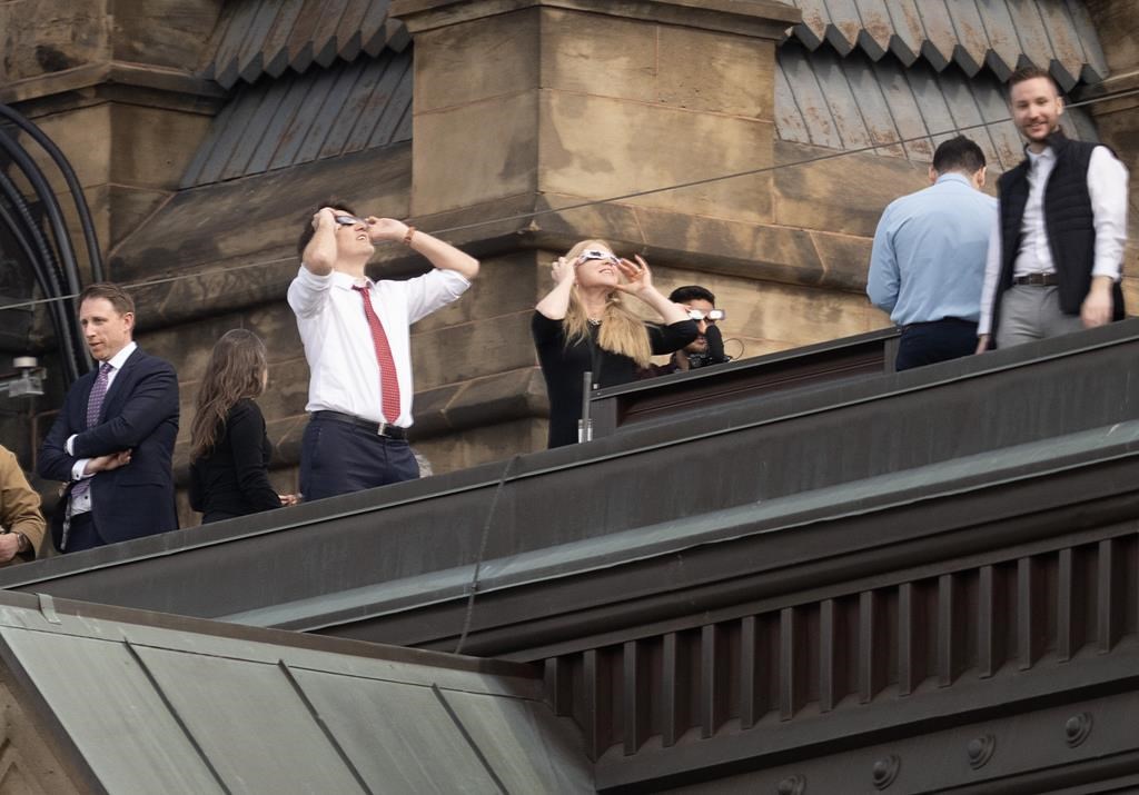 Prime Minister Justin Trudeau takes in the solar eclipse from the roof of the Office of the Prime Minister and Privy Council building, Monday, April 8, 2024 in Ottawa. THE CANADIAN PRESS/Adrian Wyld
