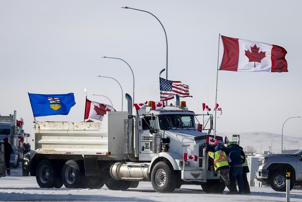 The lawyer for one of three men on trial for their roles in the border blockade at Coutts, Alta, argued Thursday his client was nothing more than a messenger. Drivers work to move a gravel truck at a protest blockade at the Canada-United States border at Coutts, Alta., Wednesday, Feb. 2, 2022.