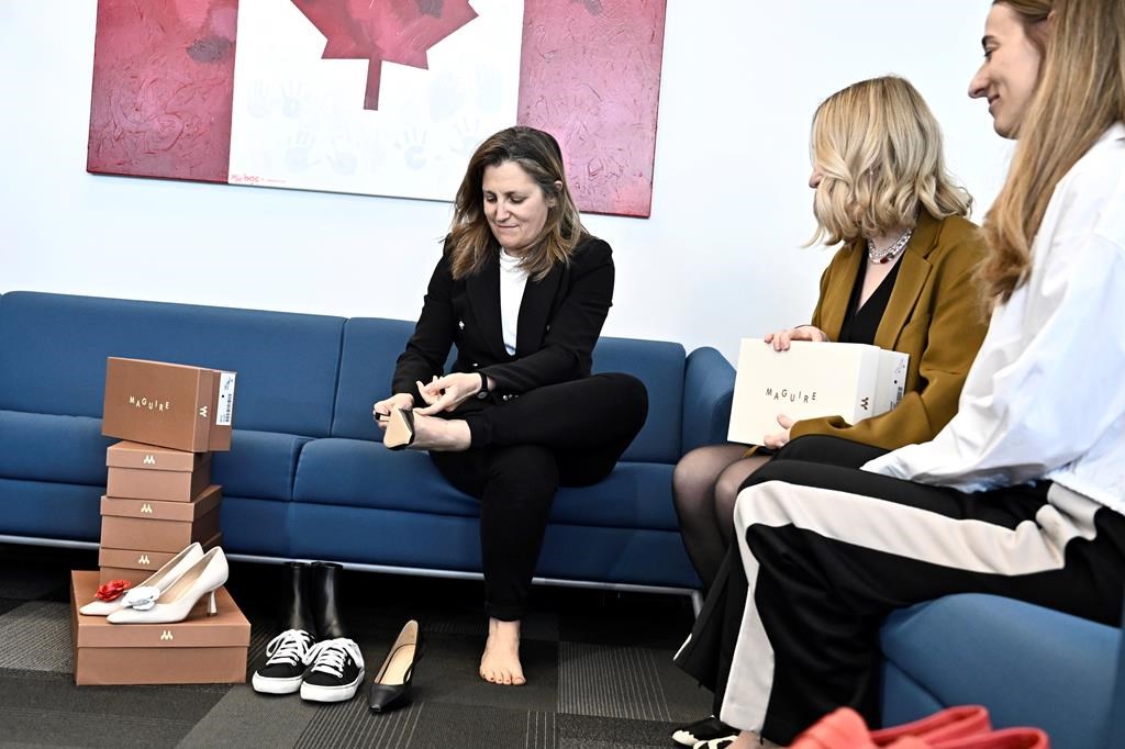 Deputy Prime Minister and Minister of Finance Chrystia Freeland tries on a pair of shoes from direct-to-consumer footwear company Maguire during a pre-budget photo op in her office in Ottawa, Monday, April 15, 2024.