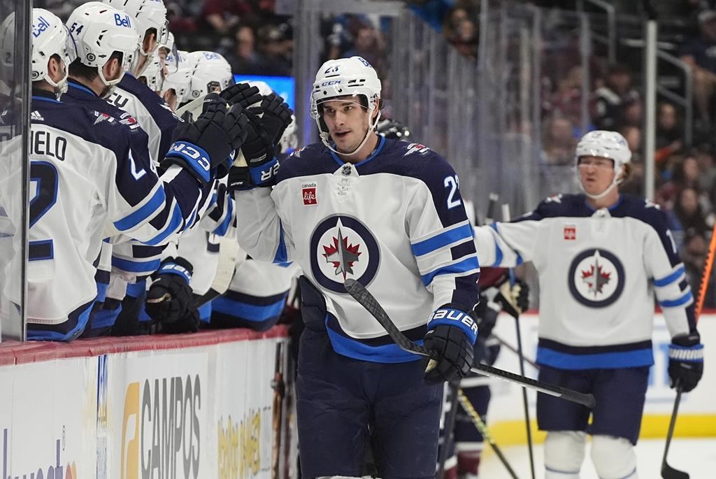 Winnipeg Jets centre Sean Monahan, front right, is congratulated after scoring in the first period of an NHL hockey game against the Colorado Avalanche, Saturday, April 13, 2024, in Denver.