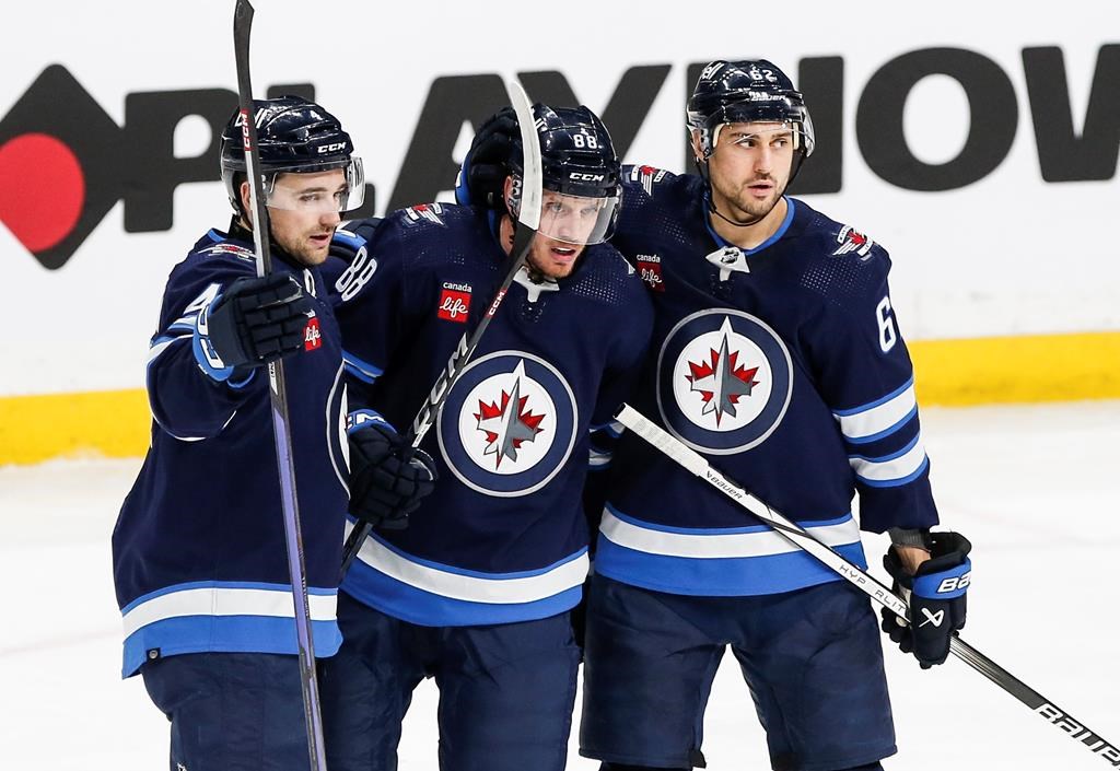 Winnipeg Jets' (left to right) Neal Pionk, Nate Schmidt and Nino Niederreiter celebrate Schmidt's goal against the Anaheim Ducks during a game in Winnipeg on March 15.